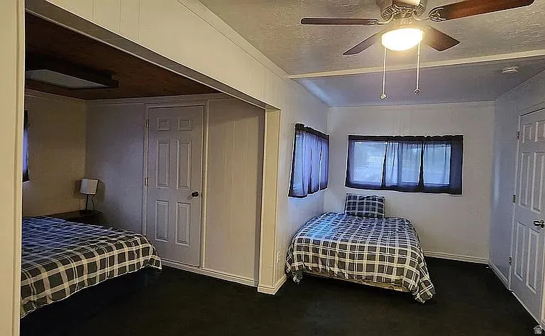 Interior room featuring dark carpet flooring and white paneled walls