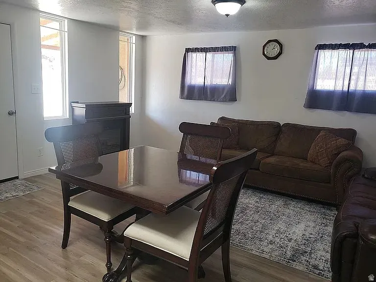 Interior space featuring wood-finish flooring, white walls, and a built-in electric fireplace