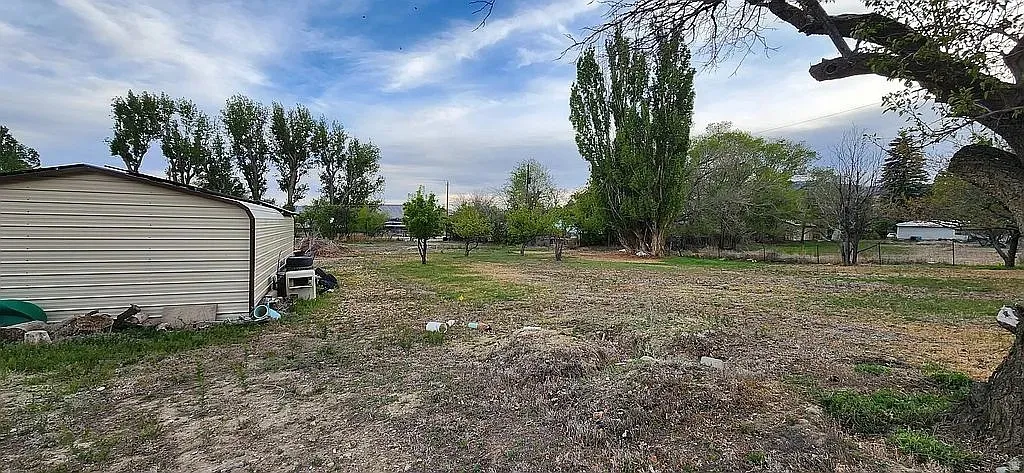 Expansive undeveloped land featuring a metal outbuilding with a sloped roof