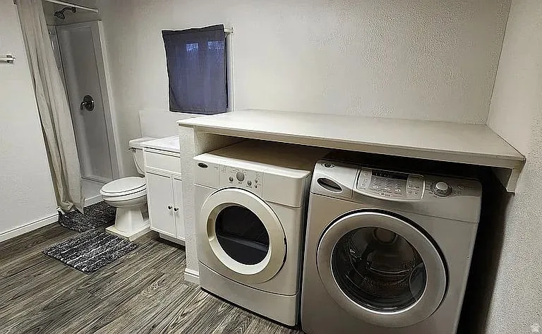 Full bathroom with wood-finish flooring, a white cabinet vanity, and a stand-up shower