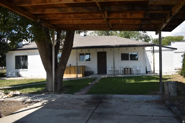 Carport with wood framing and a concrete driveway