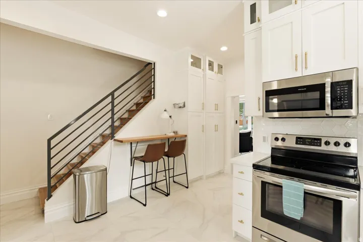 Bright kitchen with white cabinetry and stainless steel appliances
