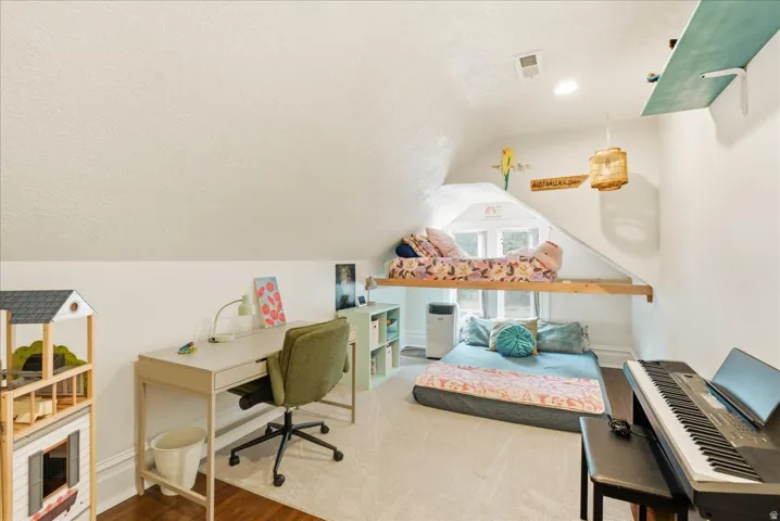 Attic room with sloped ceilings, a dormer window, recessed lighting, and a built-in elevated platform