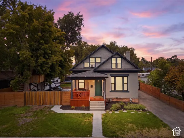 Renovated residence with an inviting covered porch and a vibrant green front lawn