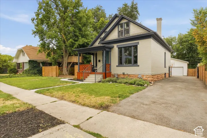 Crafted exterior featuring painted brick, dark trim accents, and a covered front porch with red-stained railings