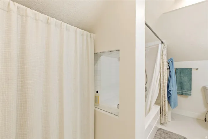 White grid-patterned shower curtain concealing a shower/tub combination