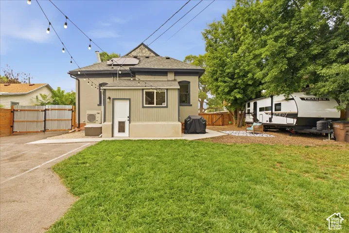 Expansive backyard featuring a lush lawn, concrete patio, and mature trees