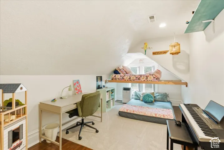 Attic room with sloped ceilings, a dormer window, recessed lighting, and a built-in elevated platform