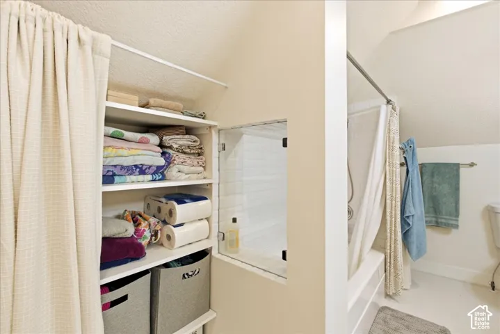Built-in shelving unit with multiple storage compartments, accompanied by a recessed wall cabinet with a glass door