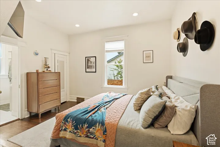 Hardwood flooring featuring an open doorway, recessed lighting, and a window with blinds