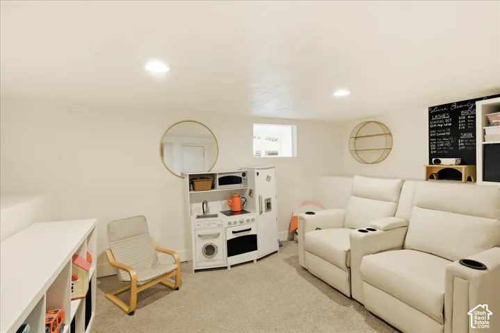 Carpeted recreational room with recessed lighting and a built-in shelving unit