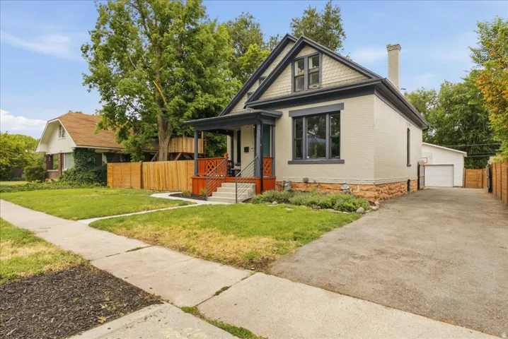 Charming traditional architecture featuring light-colored brick siding, a dark trim accent, and an attic dormer window