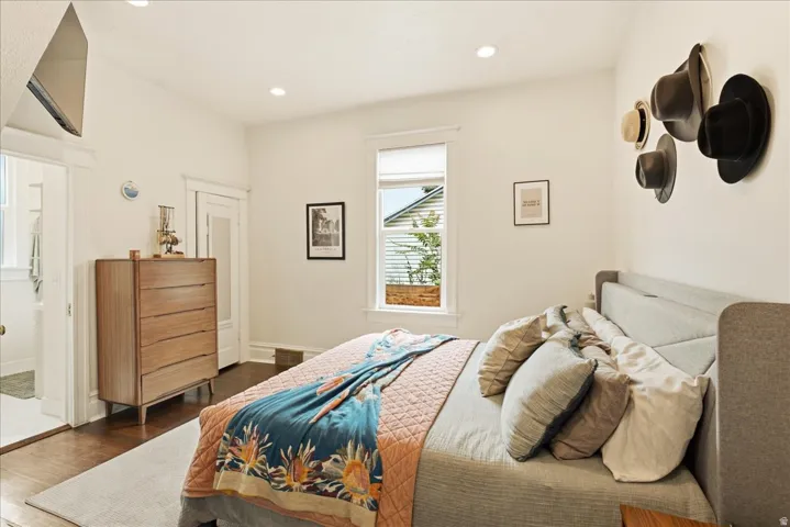 Hardwood flooring featuring an open doorway, recessed lighting, and a window with blinds
