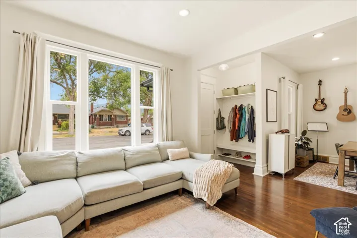 Bright living area featuring a large multi-pane window with white trim, recessed lighting, wood-finish flooring, and a built-in entryway organizer