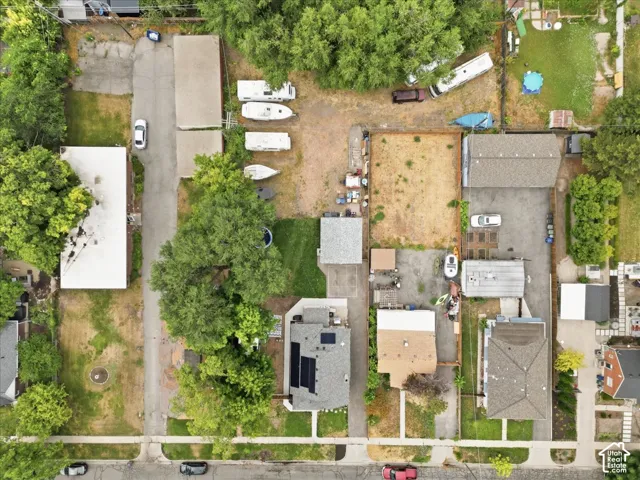 Aerial perspective showcasing multiple residential properties, mature trees, and paved streets