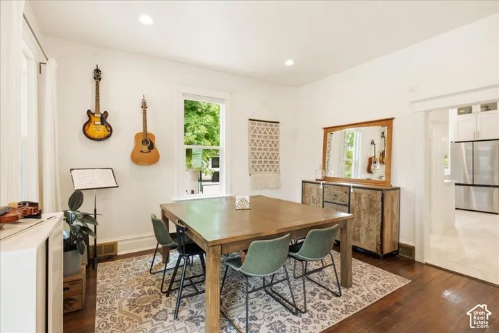 Dining area featuring wood-finish flooring, recessed lighting, a window with natural light, and a wide entryway