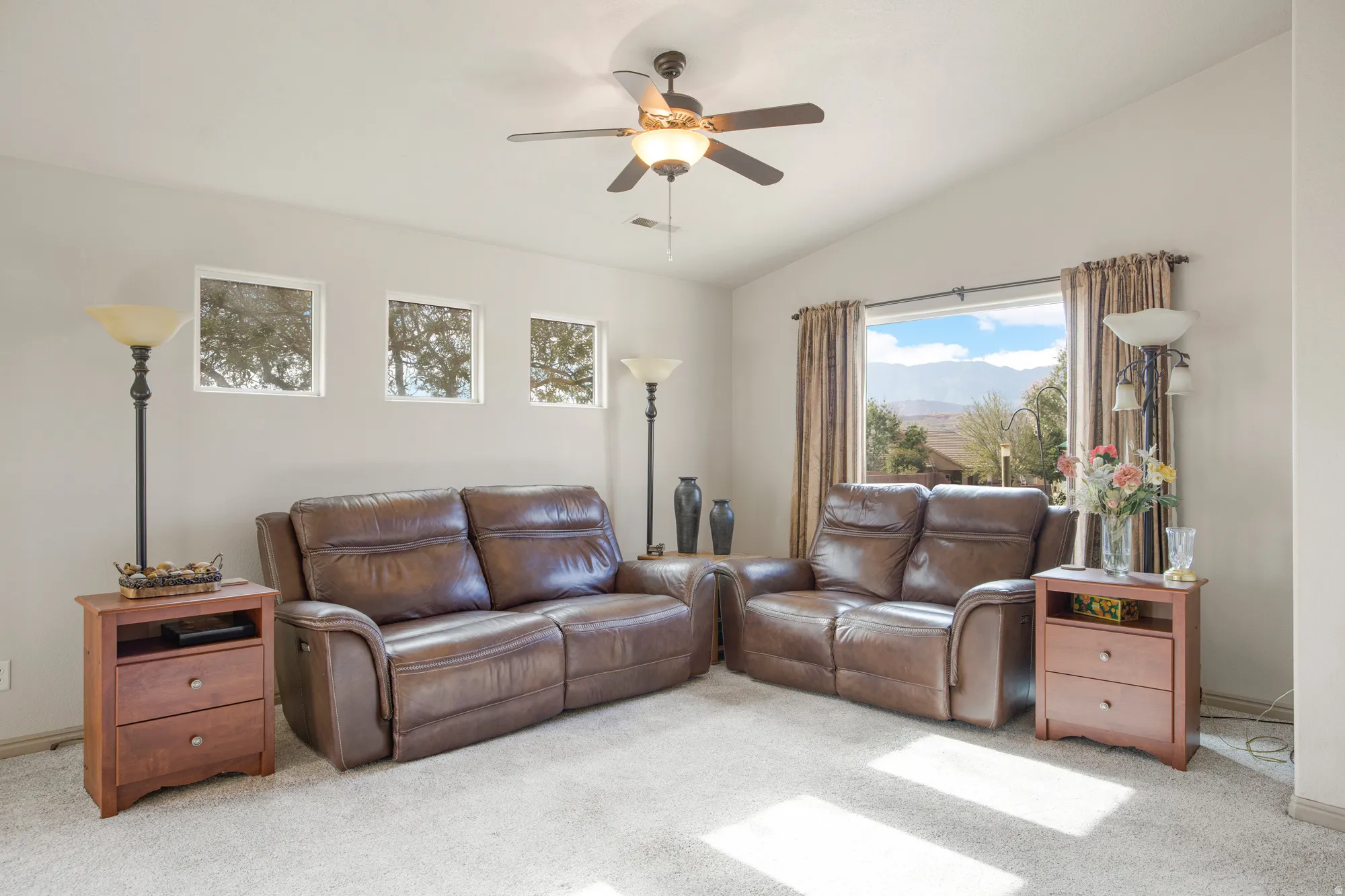 Spacious interior featuring a vaulted ceiling, ceiling fan, and light-toned wall paint