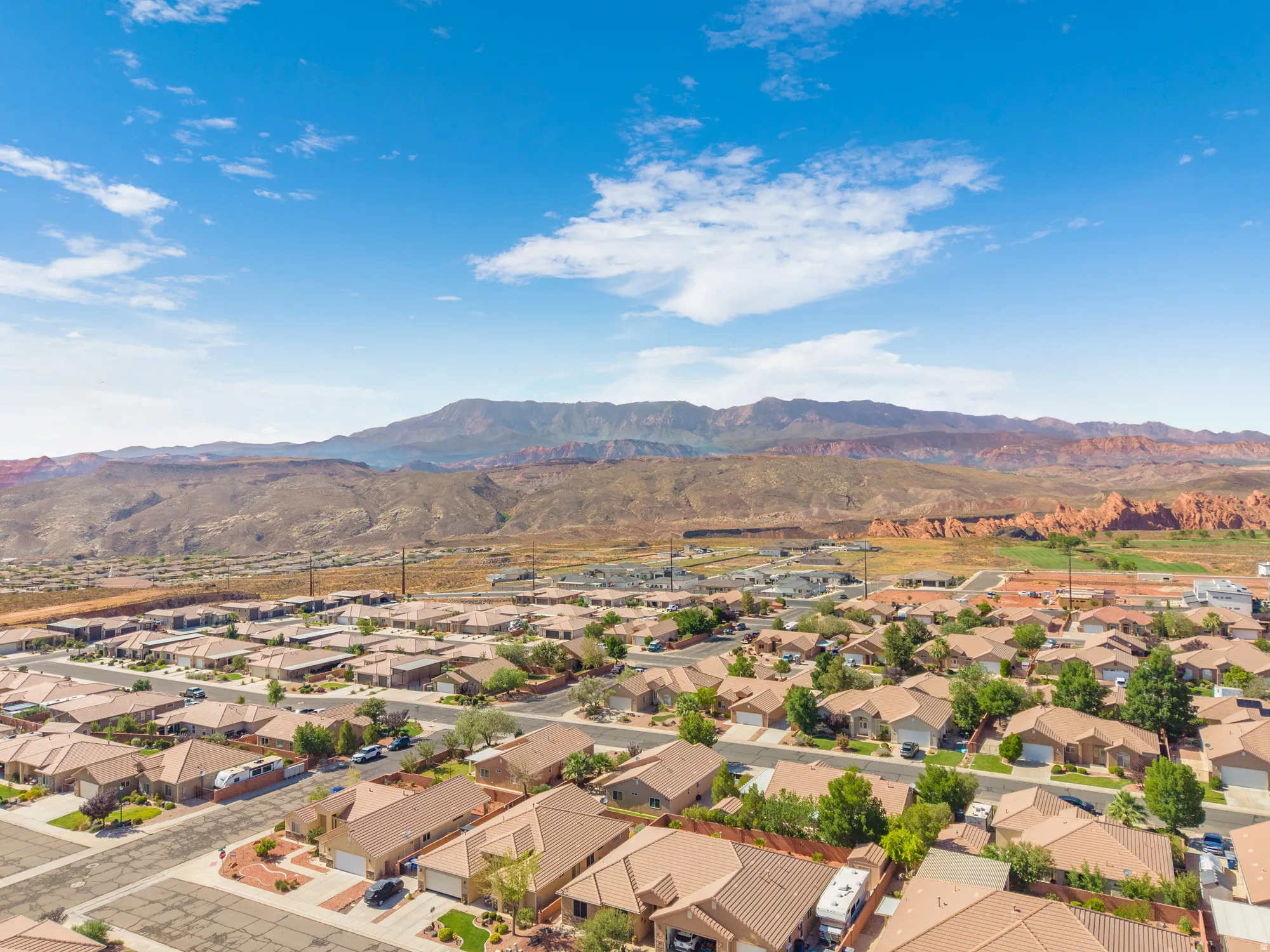 Expansive aerial capture showcasing a residential community set against a backdrop of distant mountains