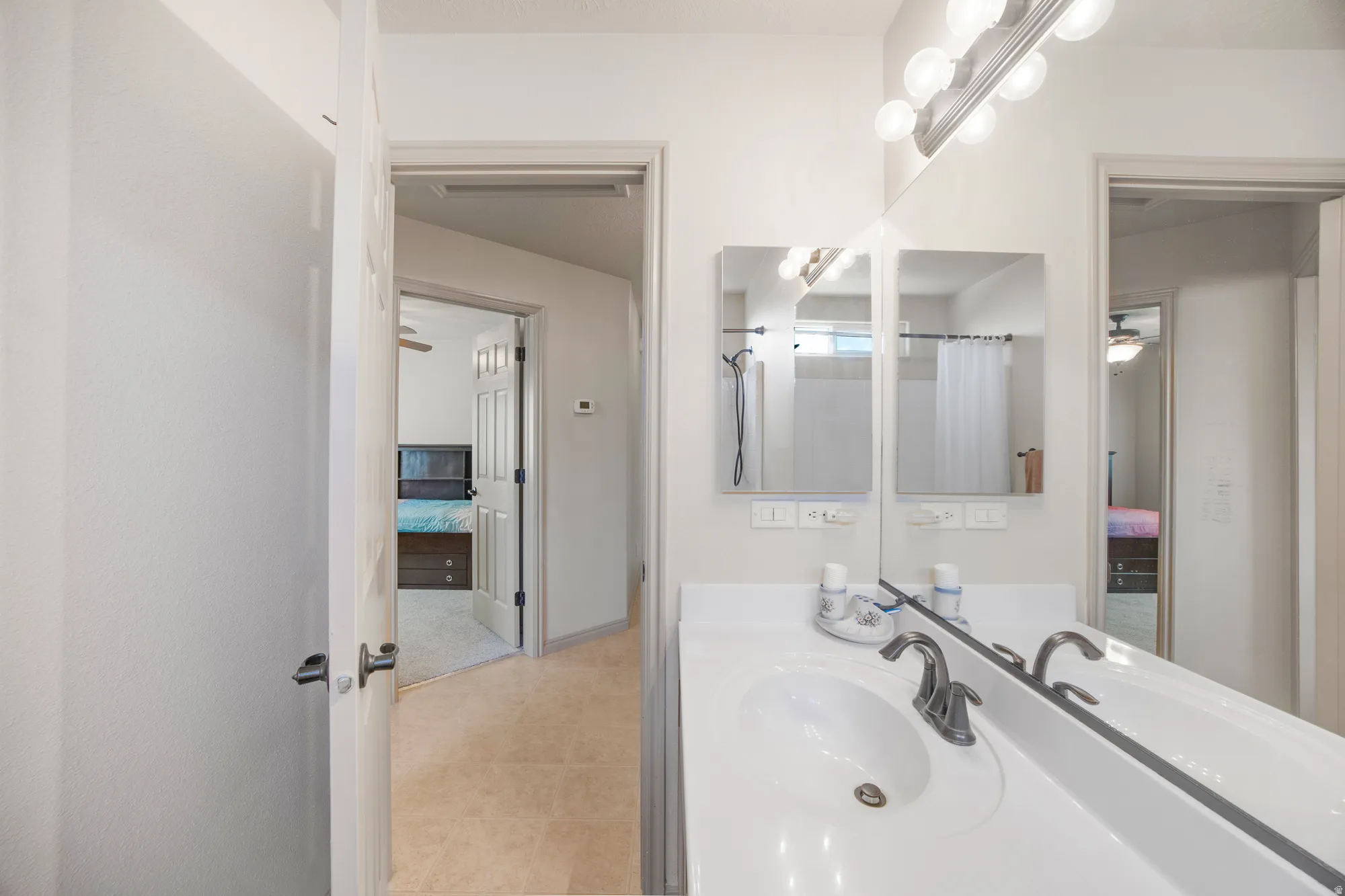 Bathroom vanity featuring an integrated sink, brushed nickel faucet, and dual mirrored medicine cabinets