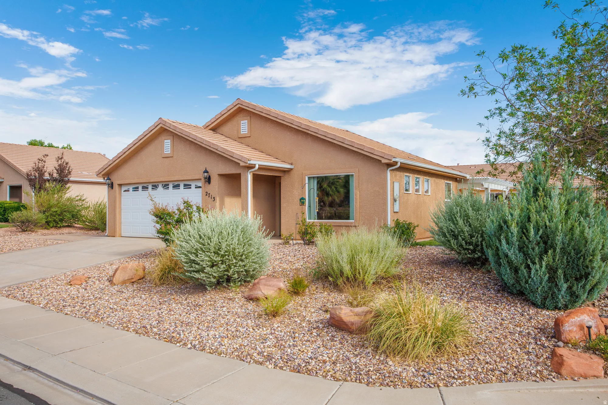 Stucco exterior residence with a two-car garage and a tile roof