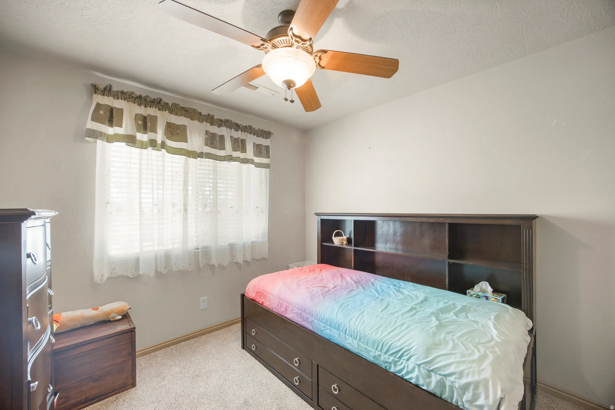 Carpeted room featuring a ceiling fan with integrated lighting, a window with horizontal blinds, and neutral wall tones