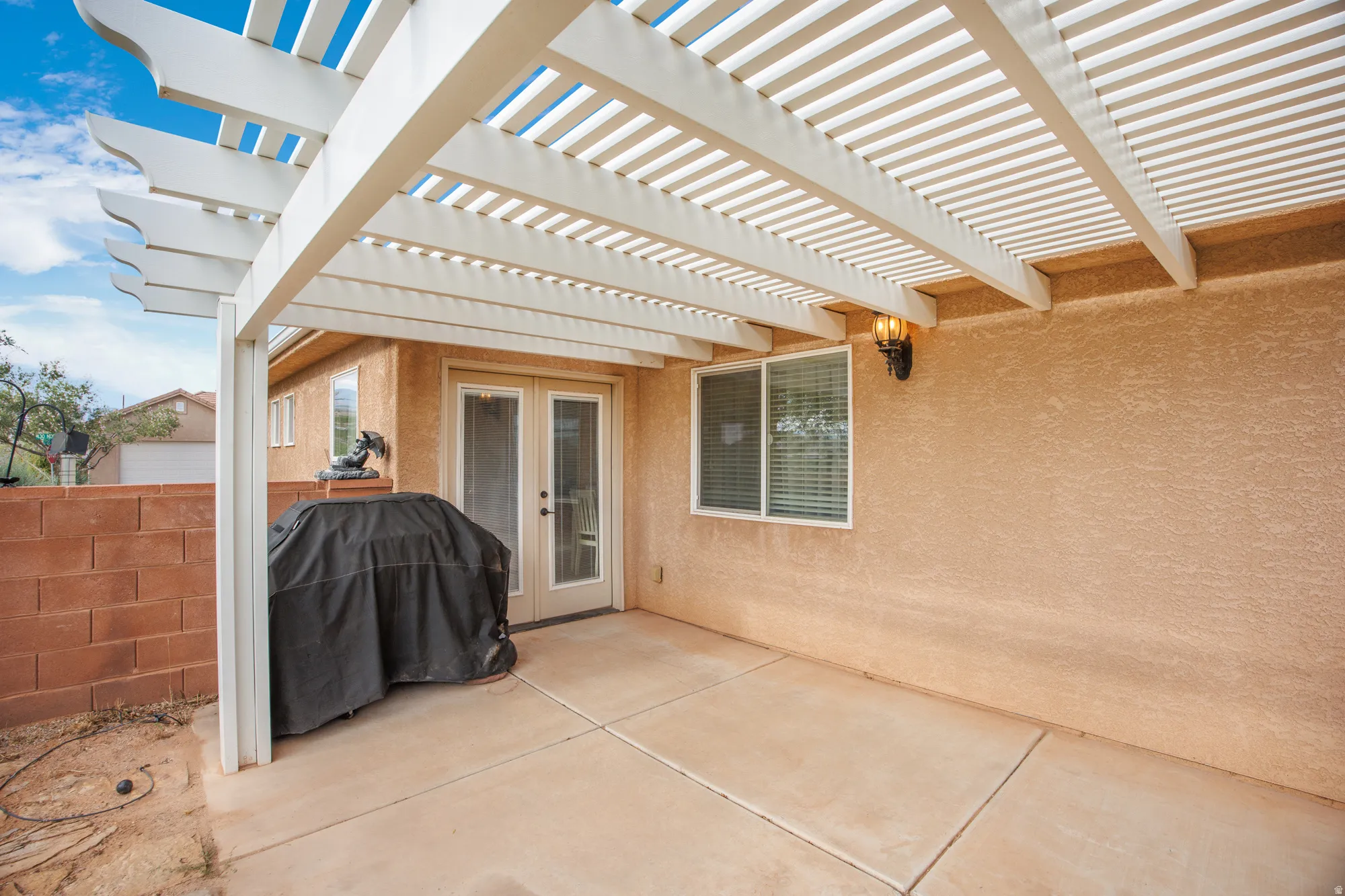 Covered patio space featuring a white lattice pergola
