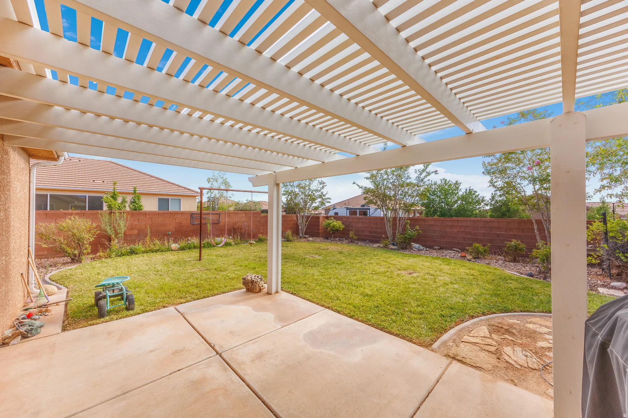 Expansive patio with a slatted pergola overhead