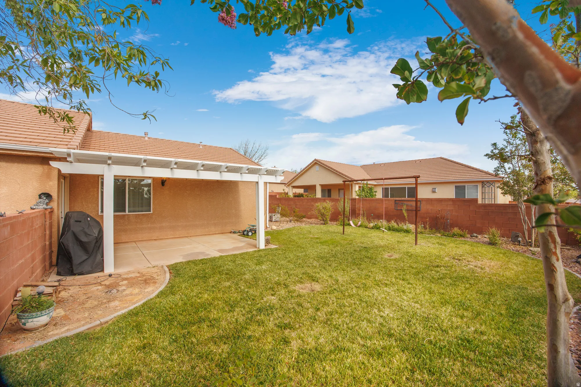 Expansive backyard featuring a lush lawn and a concrete patio