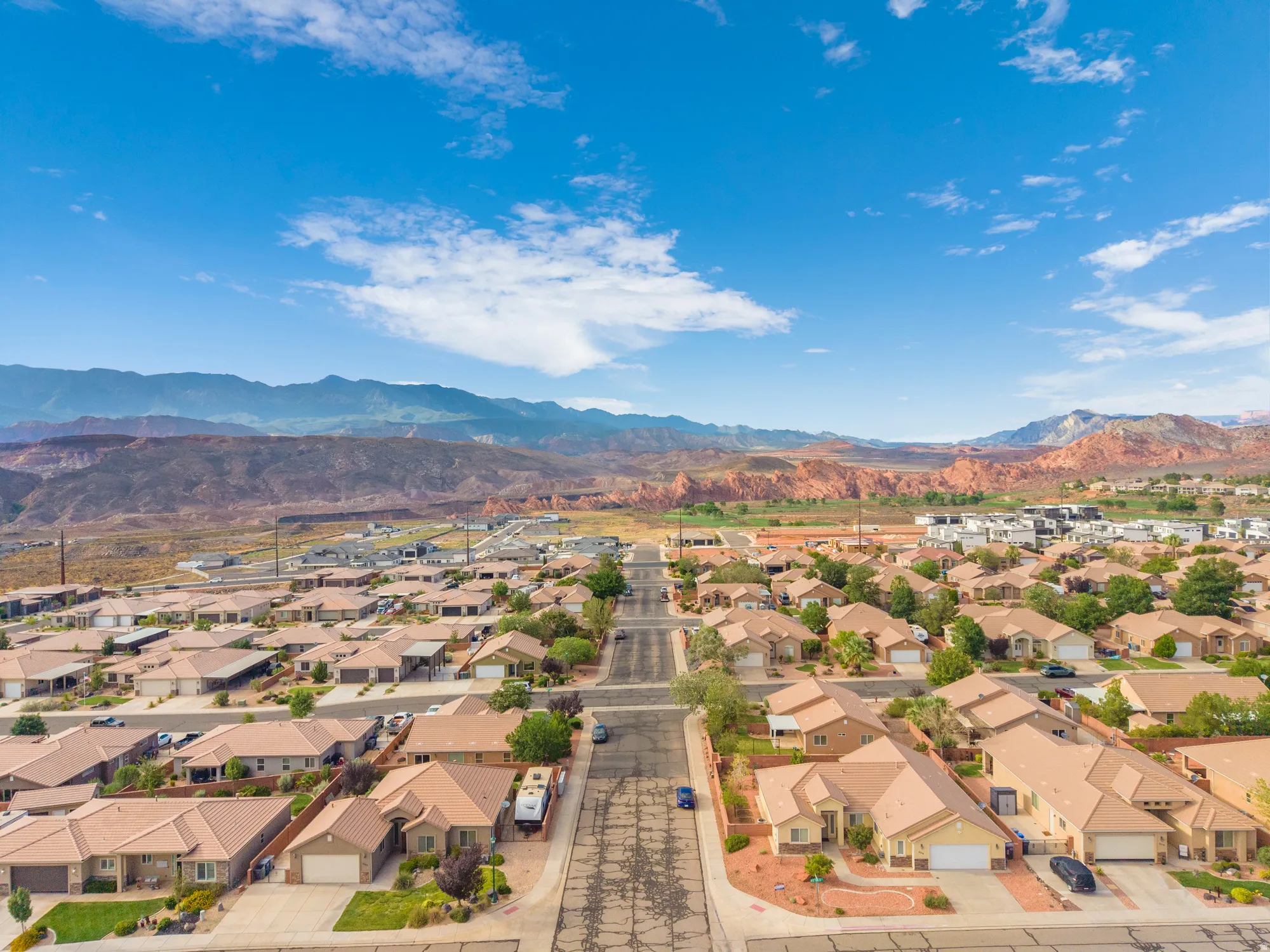 Expansive neighborhood setting featuring a diverse collection of single-story residences, paved streets, and arid landscaping