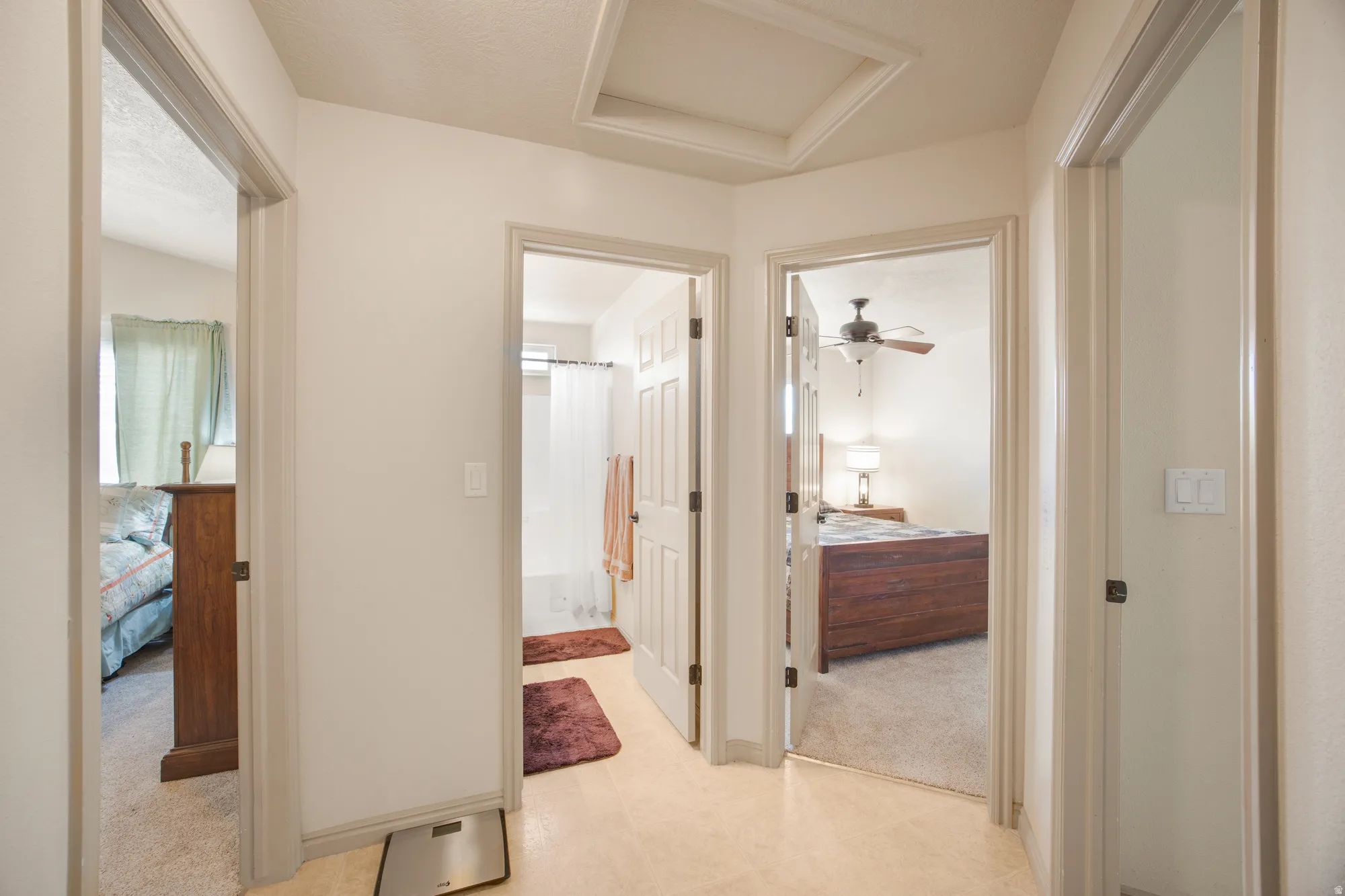 Hallway with light-toned flooring, providing access to multiple rooms