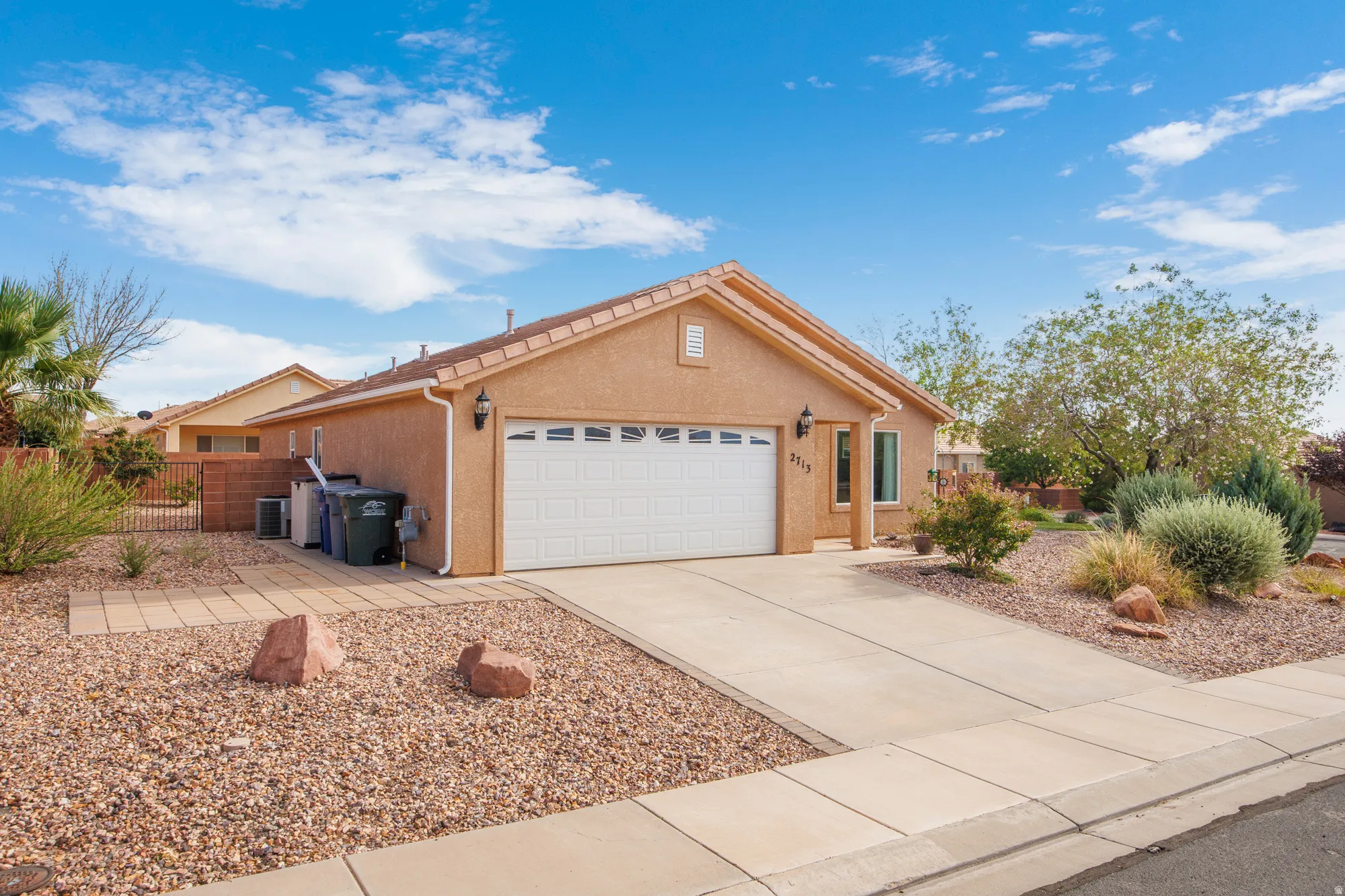 Single-story stucco residence featuring an attached garage with a white panel door