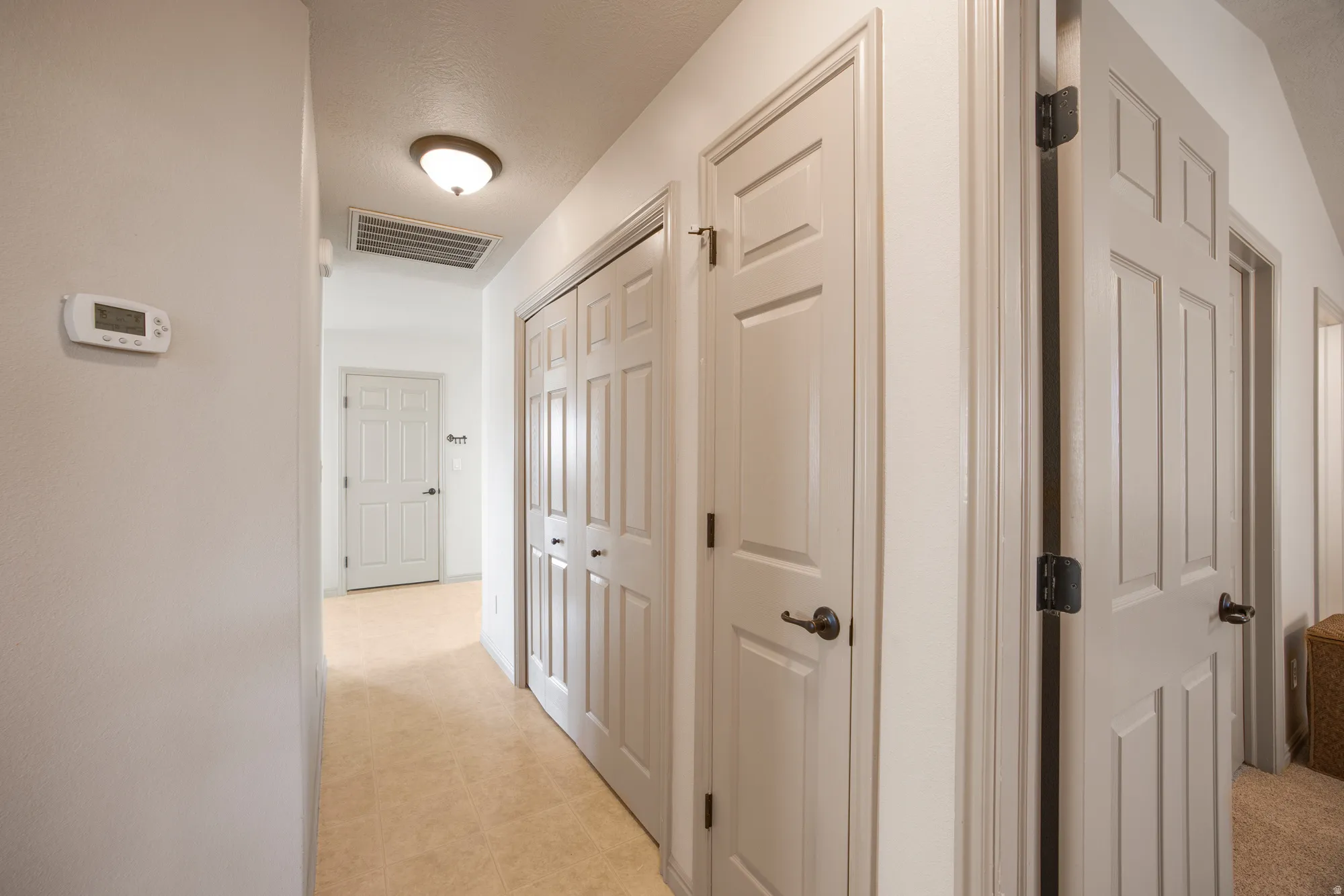 Carpeted hallway with painted walls and multiple doors