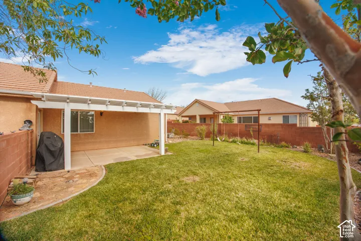 Expansive backyard featuring a lush lawn and a concrete patio