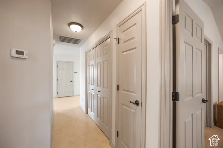 Carpeted hallway with painted walls and multiple doors