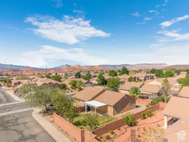 Residential neighborhood with single-story homes featuring tan stucco exteriors and terra cotta tile roofs