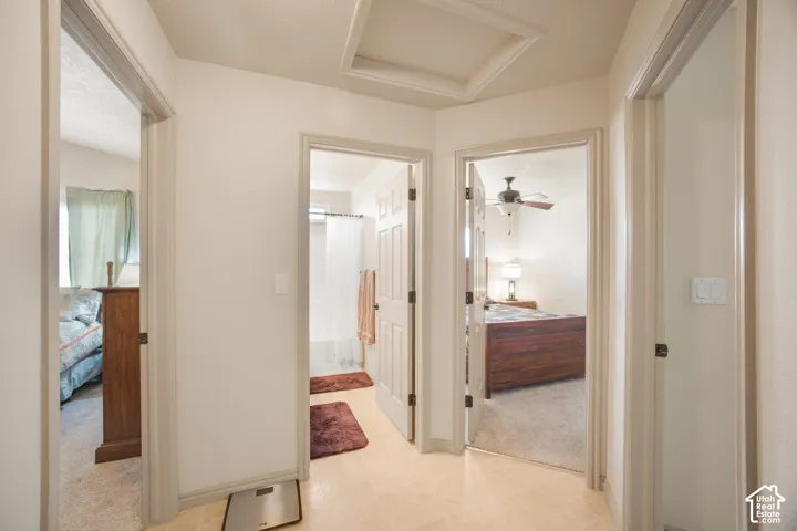 Hallway with light-toned flooring, providing access to multiple rooms