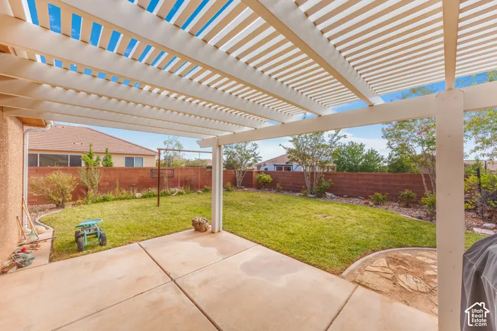 Expansive patio with a slatted pergola overhead