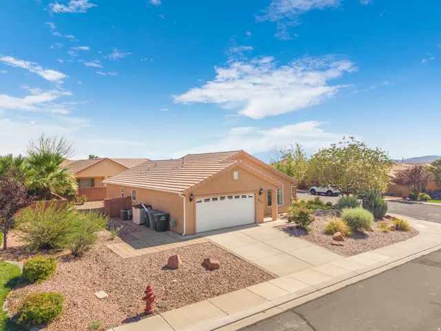 Single-story stucco residence featuring a tile roof and an attached garage