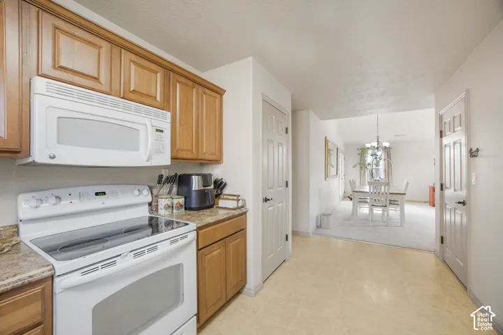 Kitchen featuring wood cabinetry, solid surface countertops, white range, and over-the-range microwave