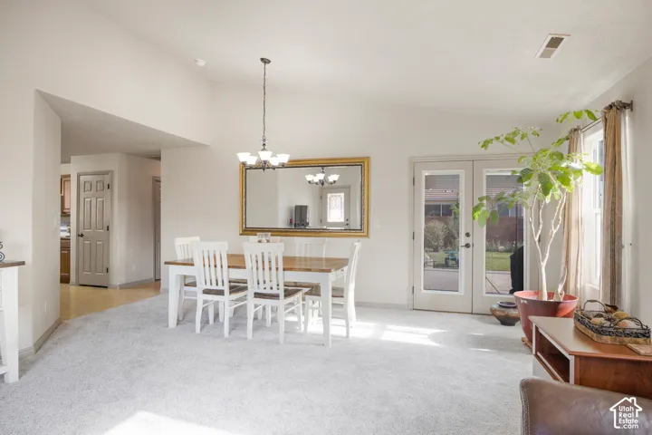 Spacious open-concept room featuring light-toned carpeting and vaulted ceilings