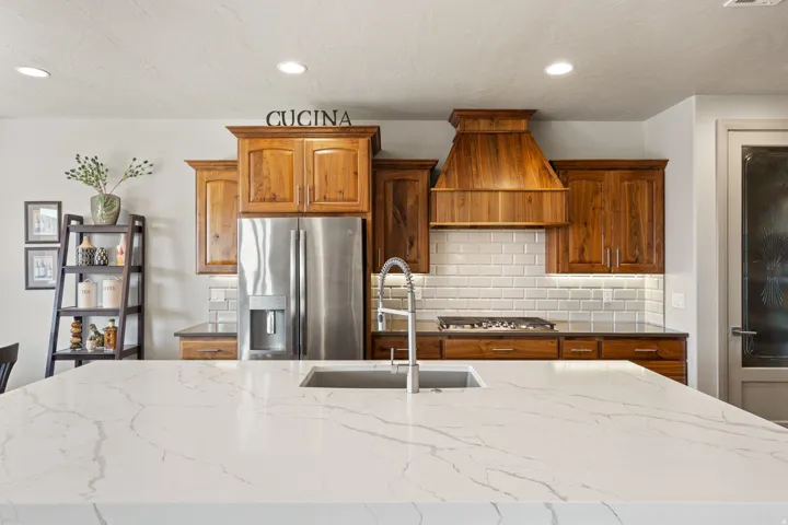 Spacious kitchen featuring a large island with an undermount sink and gooseneck faucet