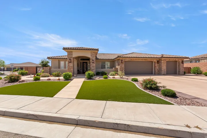 Southwestern-style residence featuring a tile roof, stucco exterior, and stone accents
