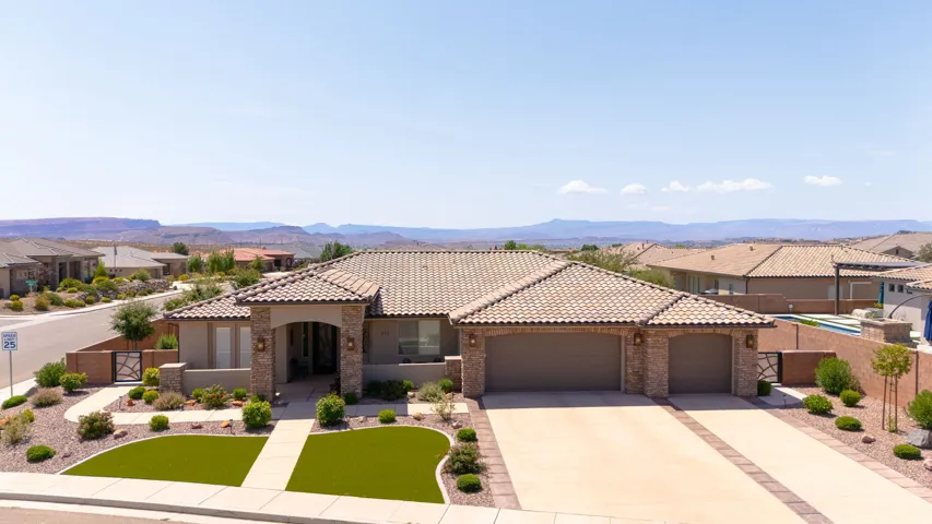 Mediterranean-style residence featuring a tile roof, stone accents, and an arched entry