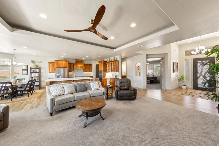 Open-concept living area with tray ceiling and recessed lighting