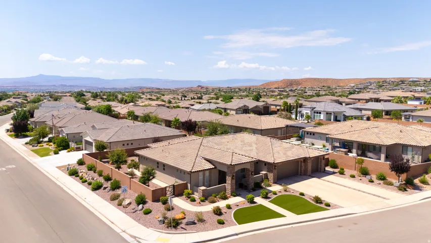 Desert landscape with a stucco exterior, tile roof, and an attached two-car garage