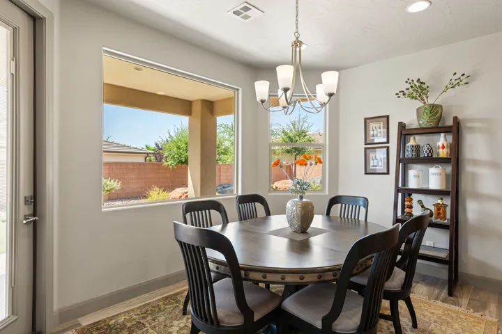 Dining area with wood-finish flooring, a contemporary chandelier, recessed lighting, and a large window providing natural light