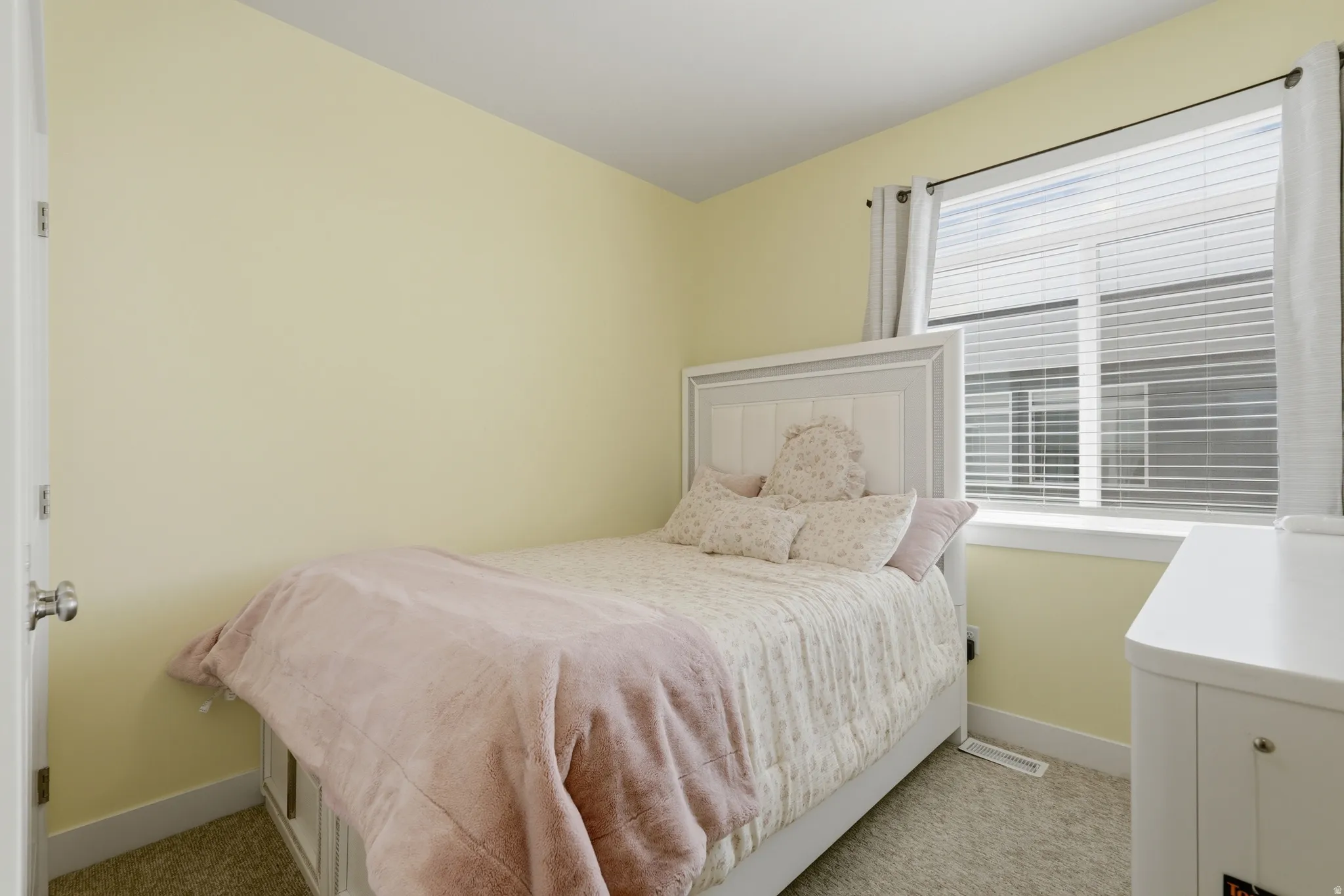 Bedroom featuring a window with blinds, light-colored walls, and carpeting