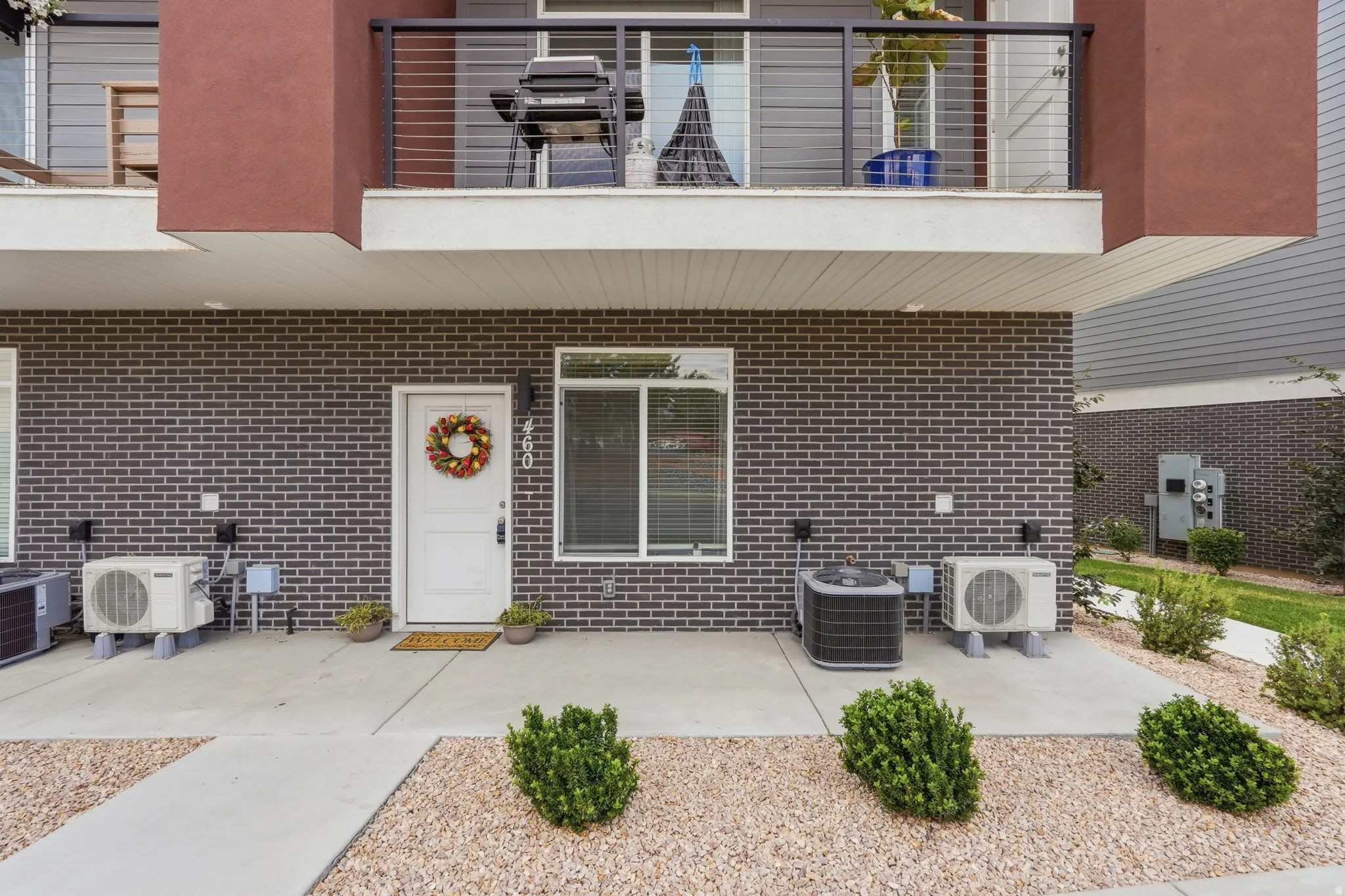 Modern facade featuring dark brick siding and a white entry door
