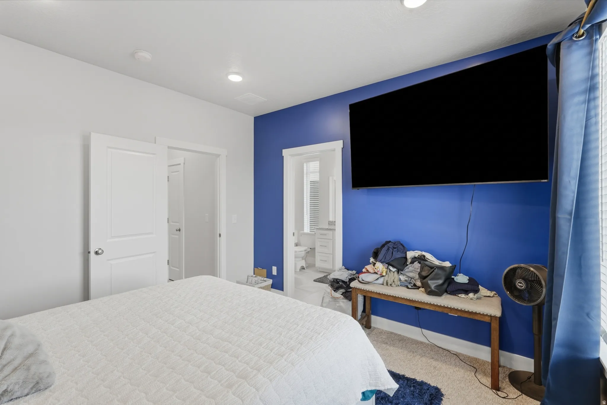 Bedroom featuring a vibrant blue accent wall