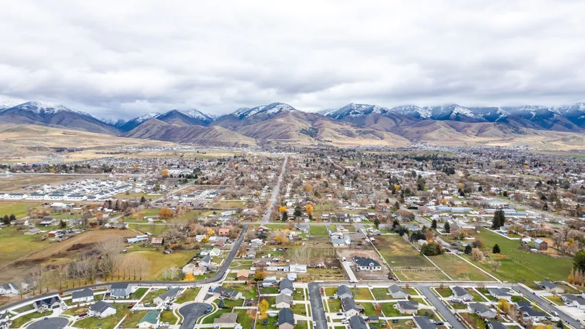 Expansive aerial perspective showcasing a residential community set against a backdrop of snow-capped mountains